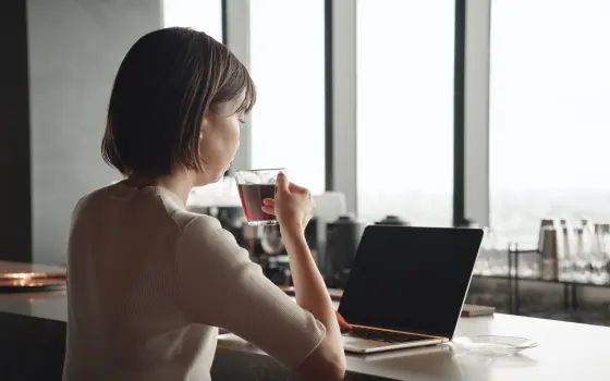 コーヒーを飲みながら作業する女性